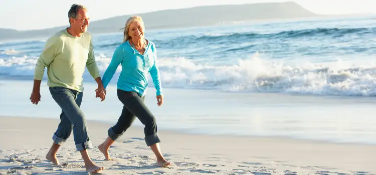 two people walking on beach waves and sand start walking begginers guide